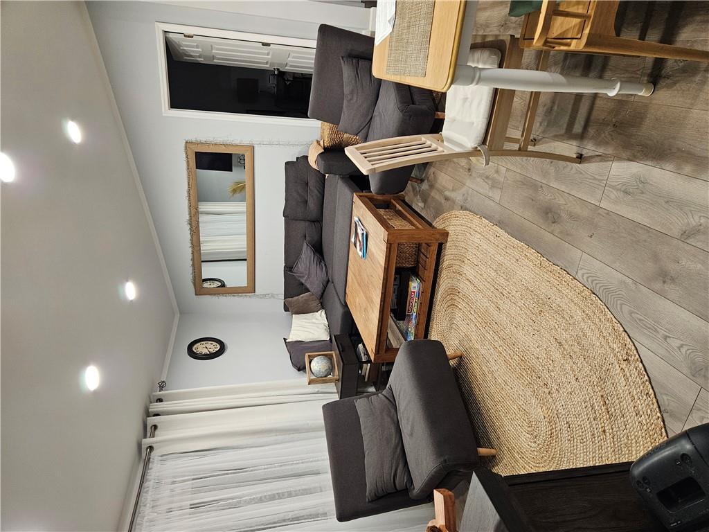 Living room with crown molding and light wood-type flooring