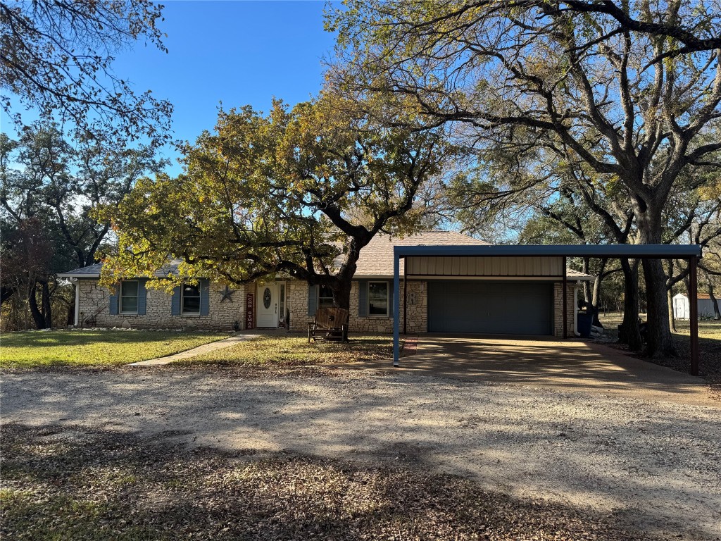 a view of a house with a yard and large tree