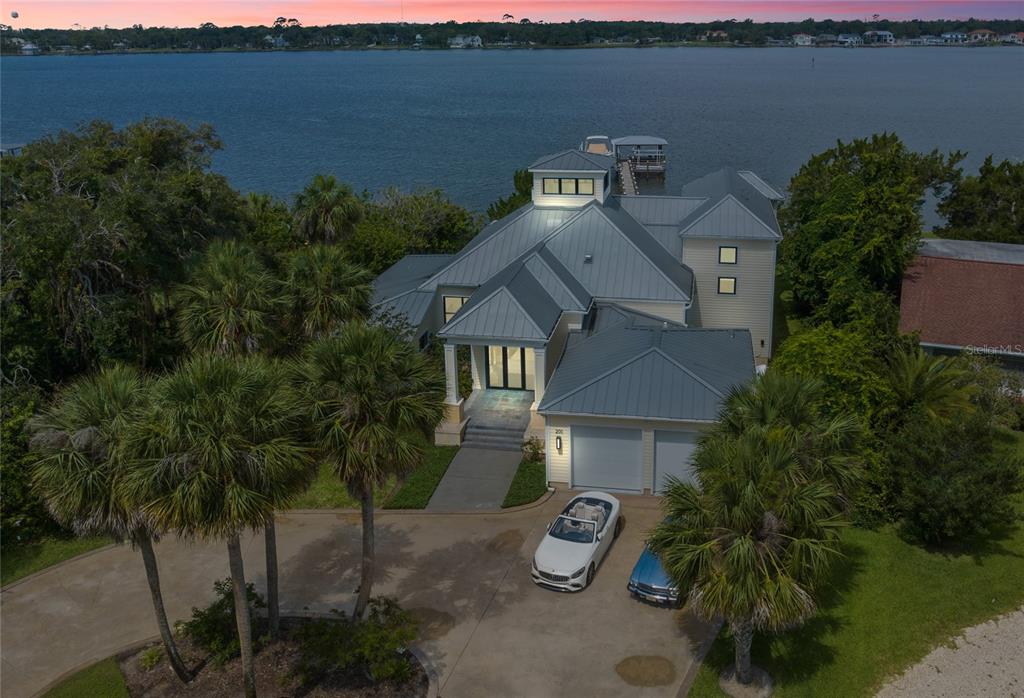 an aerial view of a house with garden space and lake view