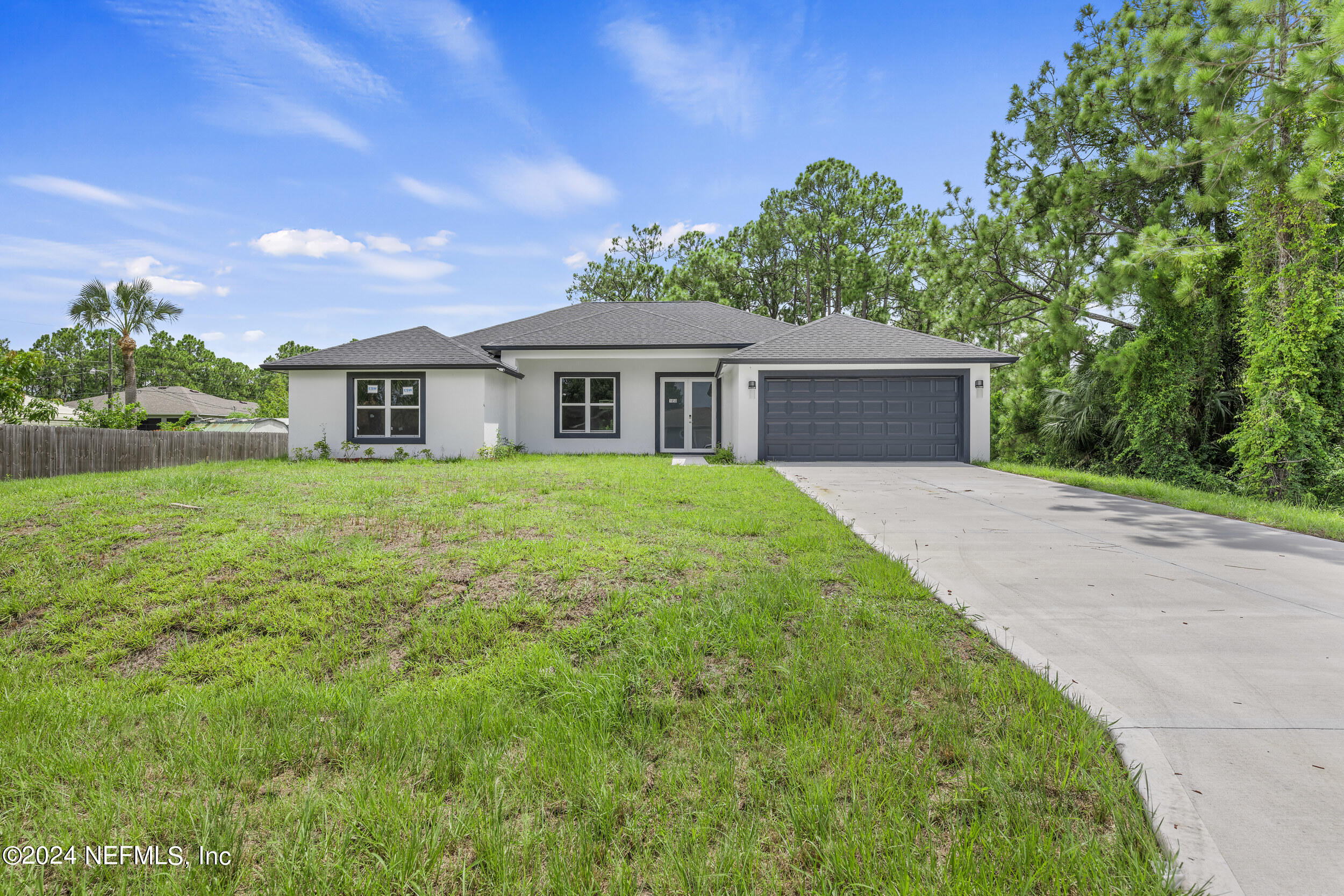 a front view of a house with yard and green space