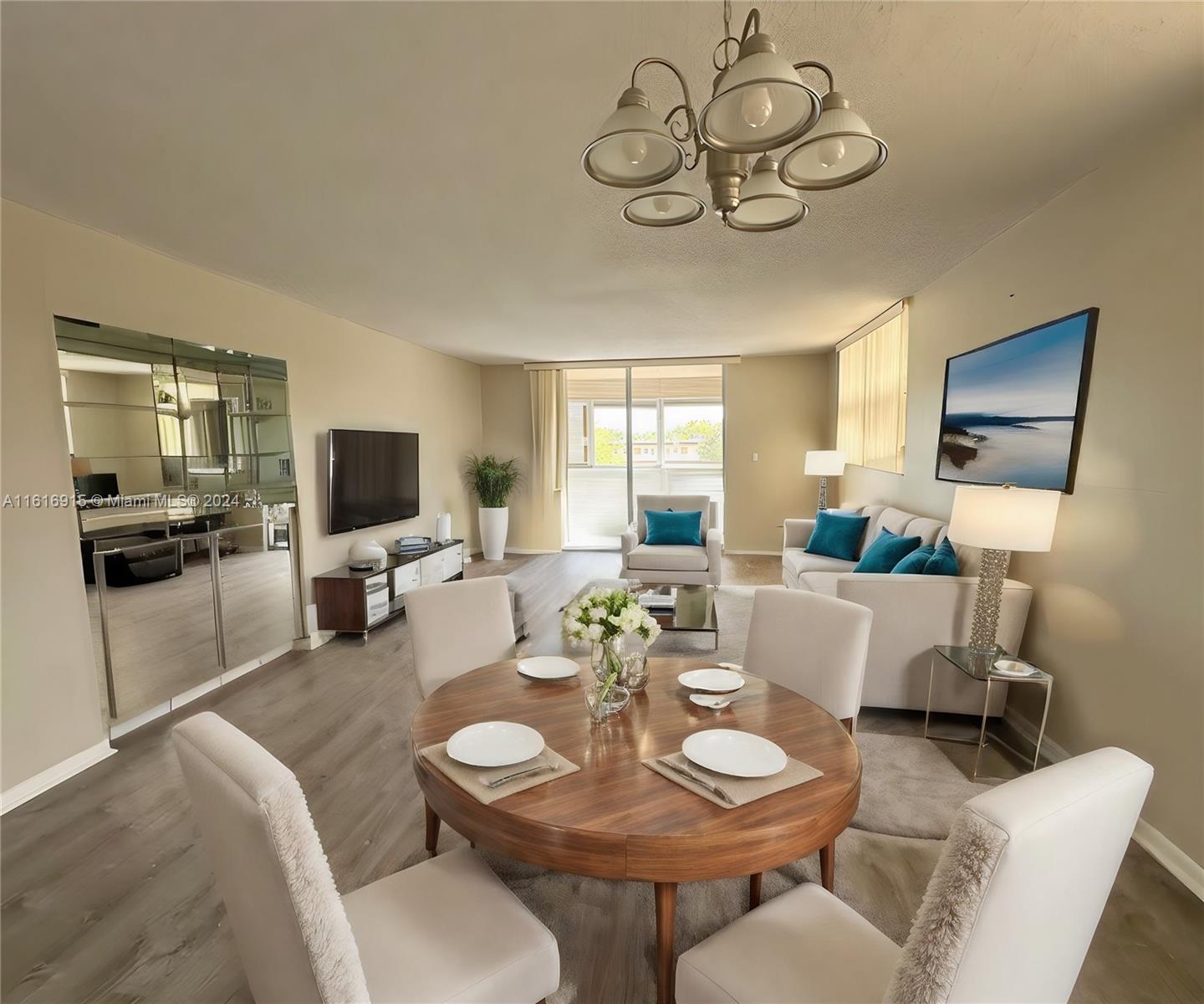 a living room with furniture a flat screen tv and kitchen view