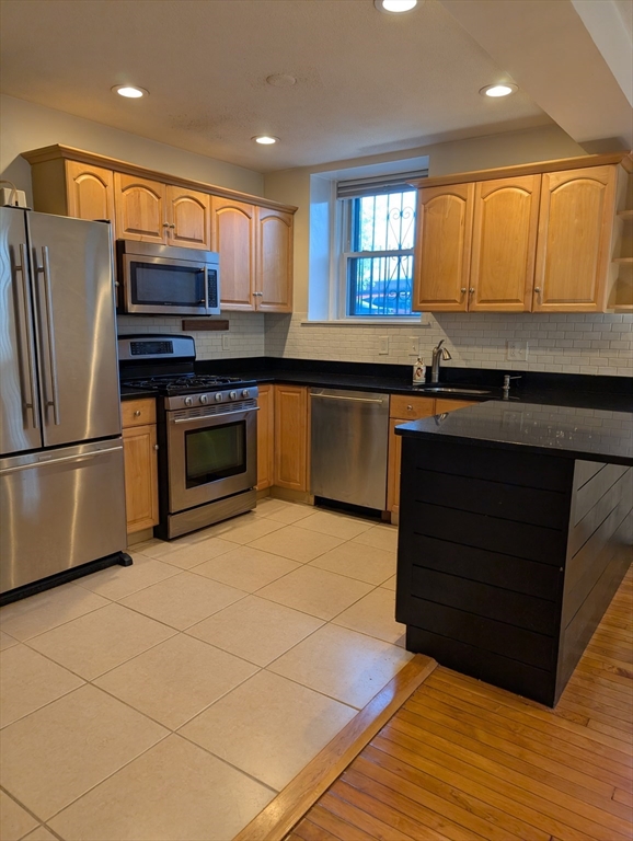 a kitchen with stainless steel appliances granite countertop a refrigerator and a sink