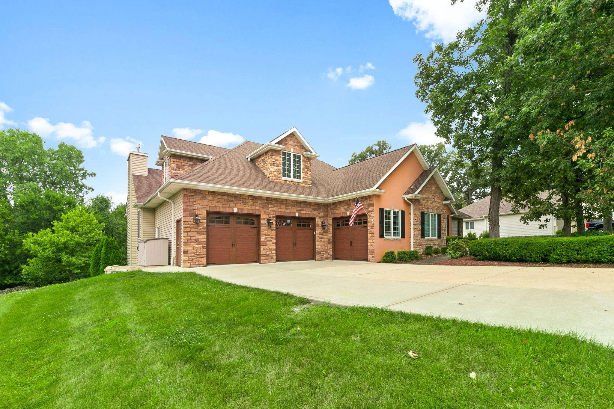 a front view of a house with a big yard and large trees