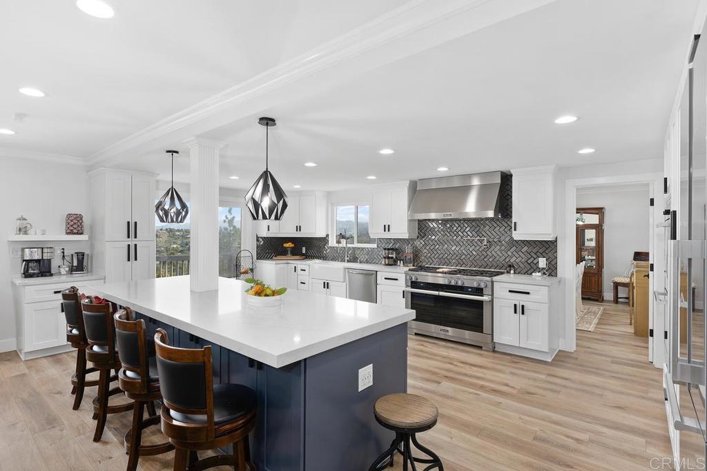 a kitchen with a stove a table and chairs in it