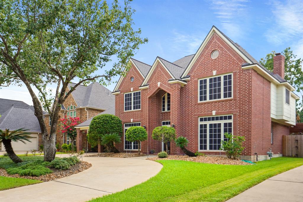 a front view of a house with a yard and green space