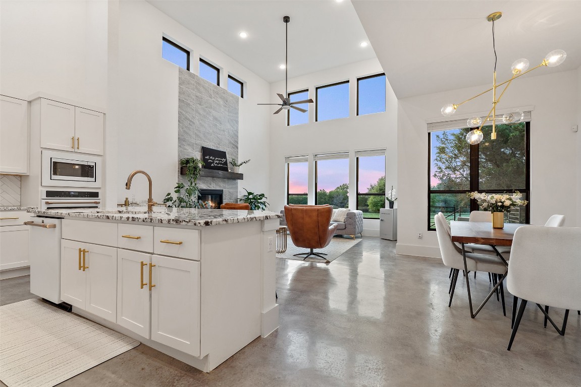 a kitchen with stainless steel appliances kitchen island granite countertop a sink and a refrigerator