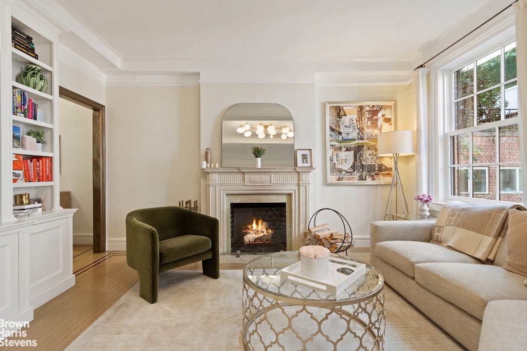 a living room with furniture a fireplace and a large window