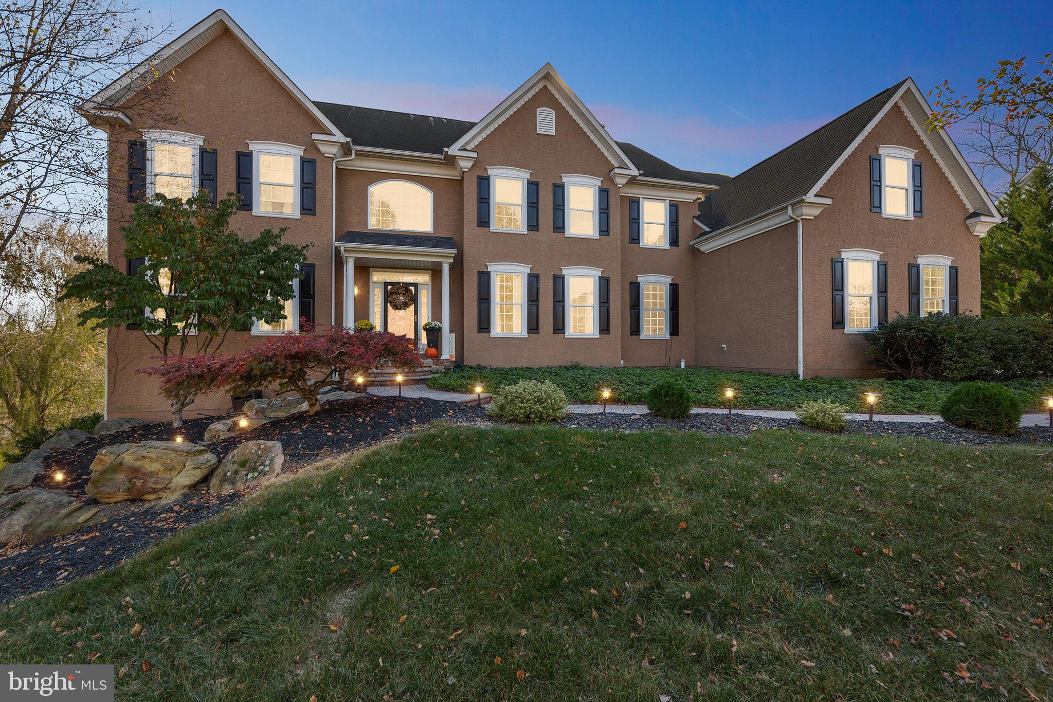 a front view of a house with yard and green space