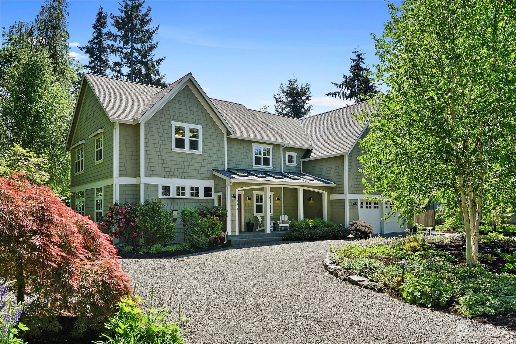 a front view of a house with a yard and potted plants