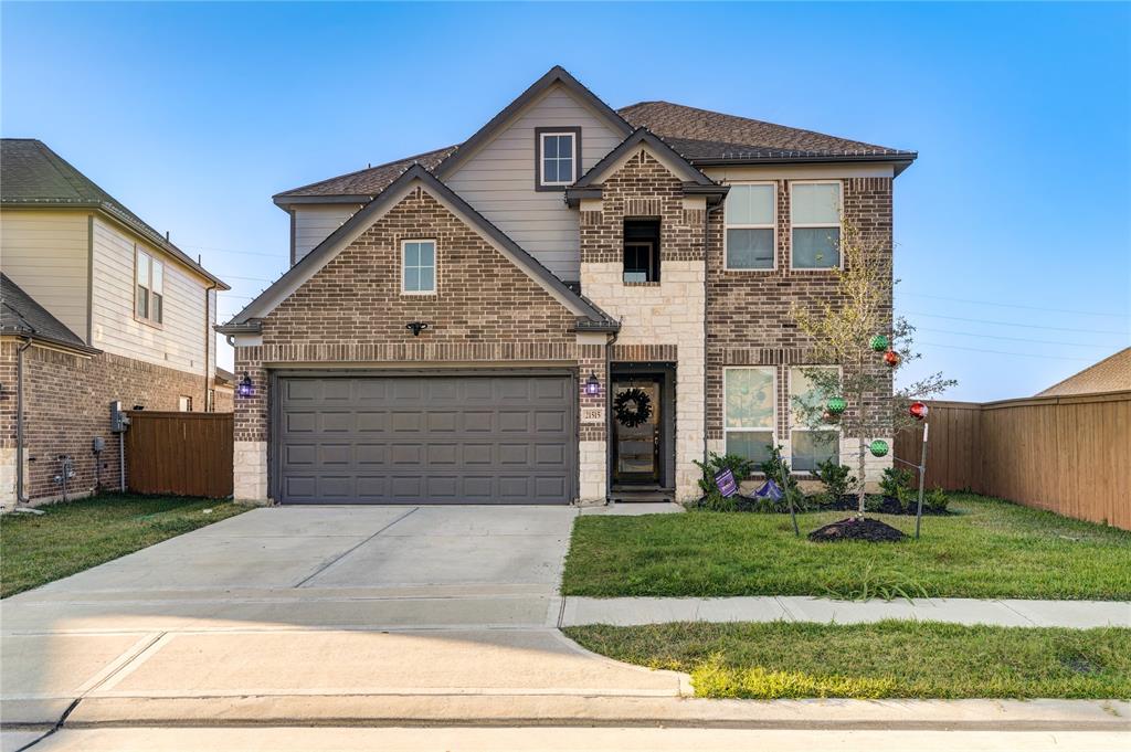 This stunning two-story home boasts a modern brick and stone exterior with charming curb appeal. The inviting entryway is framed by a covered front porch, perfect for seasonal décor or relaxing evenings. With a two-car garage and a well-maintained front lawn, this home combines elegance and functionality, offering a warm welcome to all who visit.