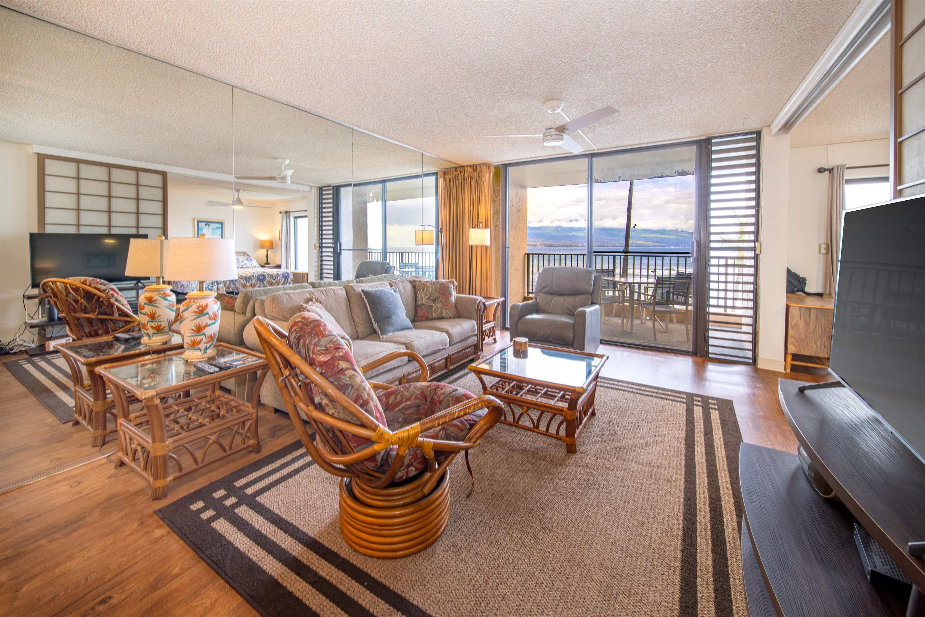 a living room with furniture a flat screen tv and a large window