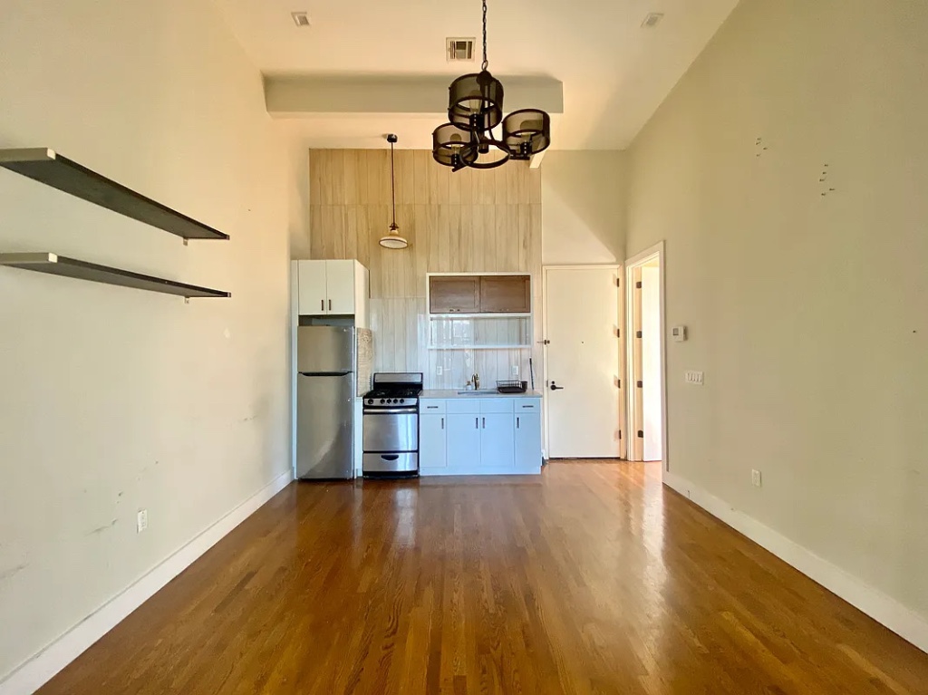 a kitchen with stainless steel appliances granite countertop a hardwood floor and window