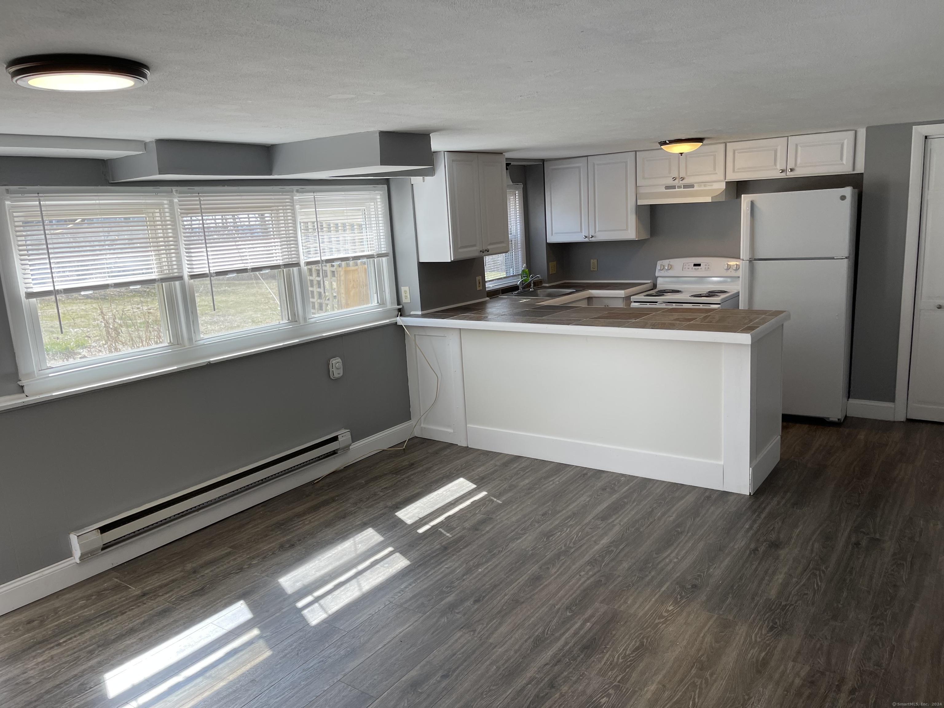 a kitchen with granite countertop a stove a sink and a refrigerator