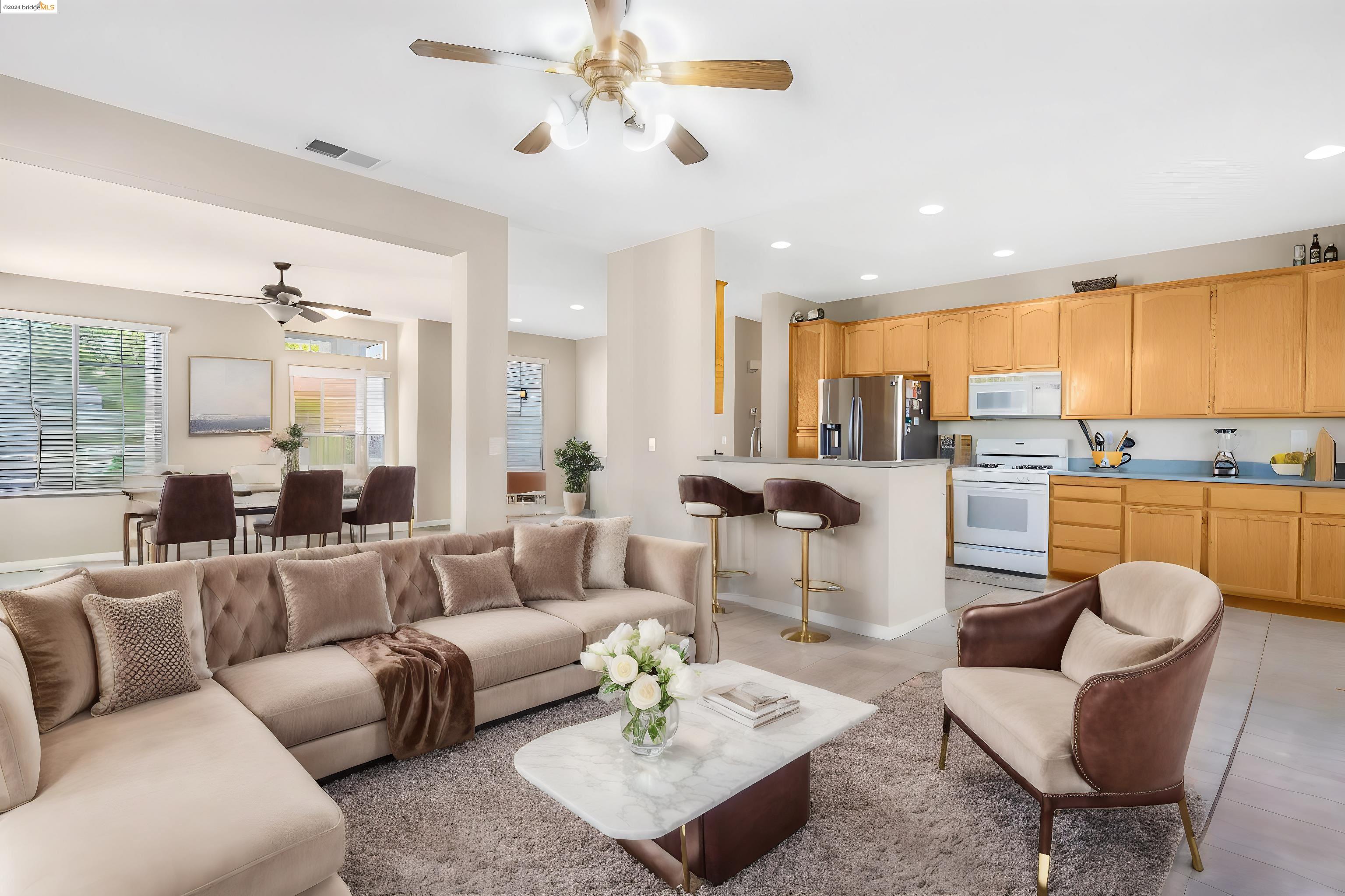 a living room with furniture kitchen view and a large window