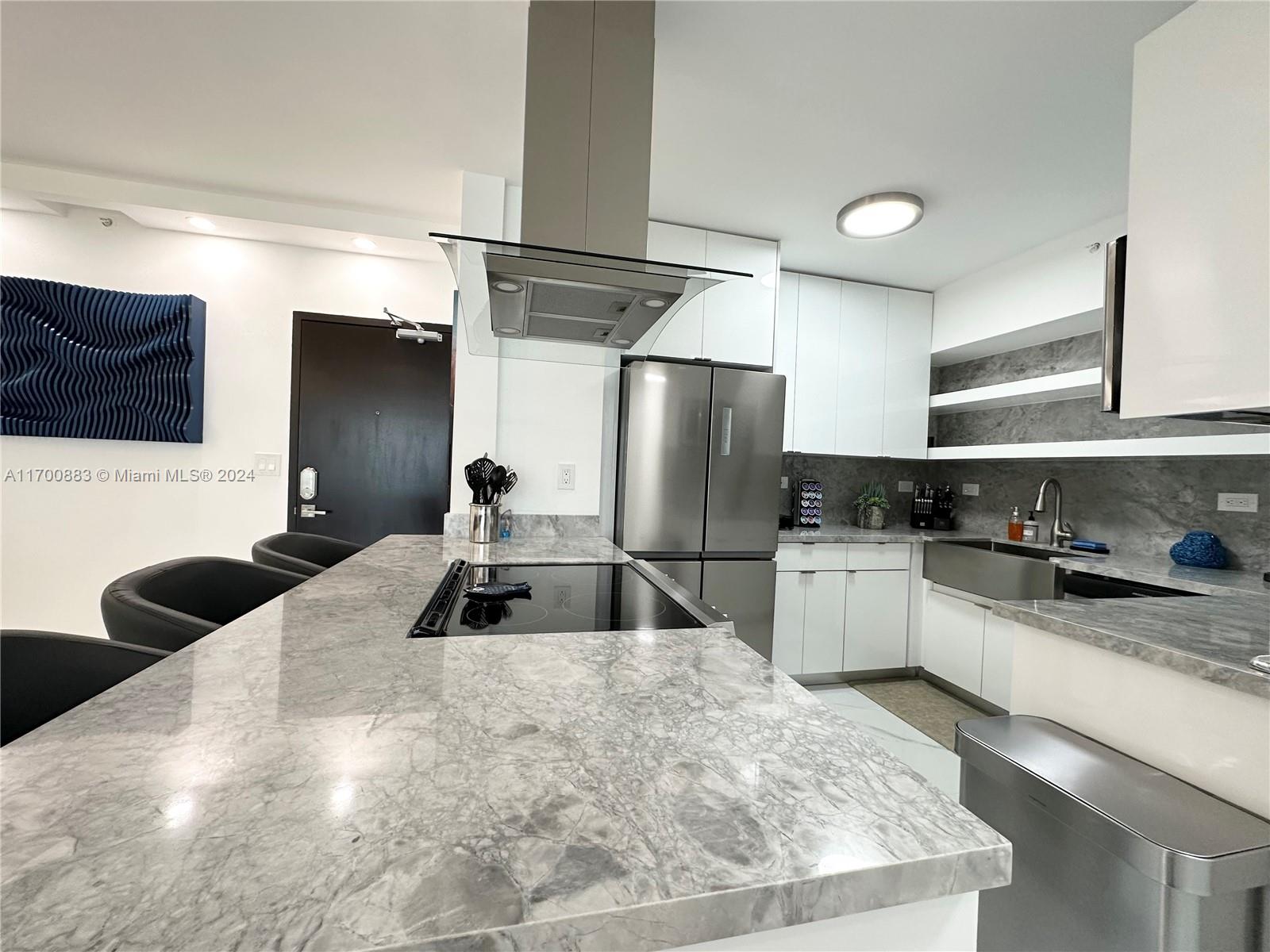 a kitchen with a sink a refrigerator and cabinets