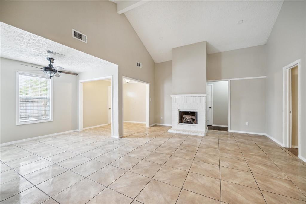 a view of an empty room with window and fire place