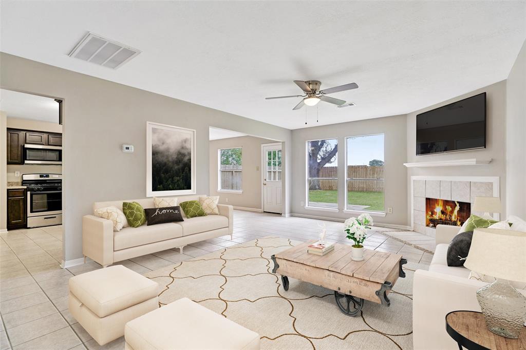 a living room with furniture a fireplace and a flat screen tv