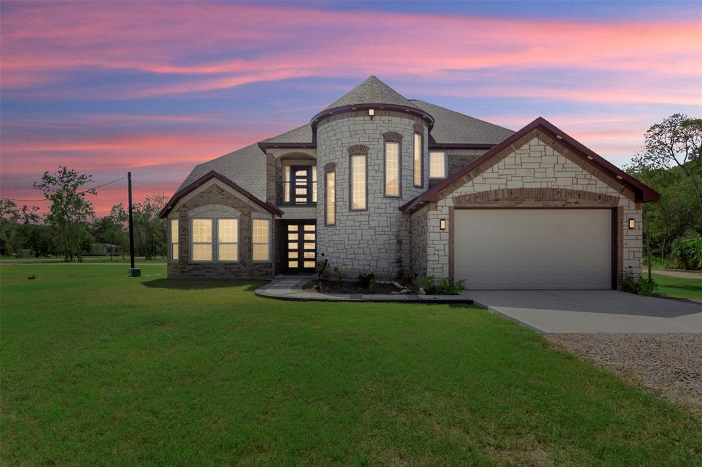 a front view of a house with a yard and garage