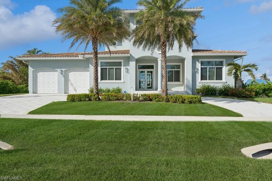 Mediterranean / spanish home with a garage and a front lawn