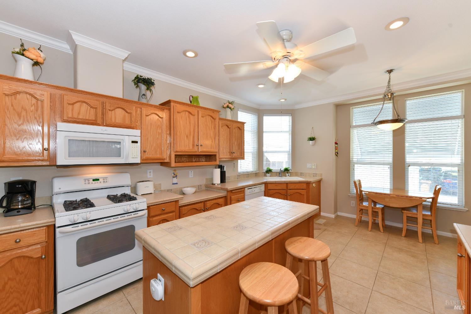 a kitchen with a stove a sink a dining table and chairs