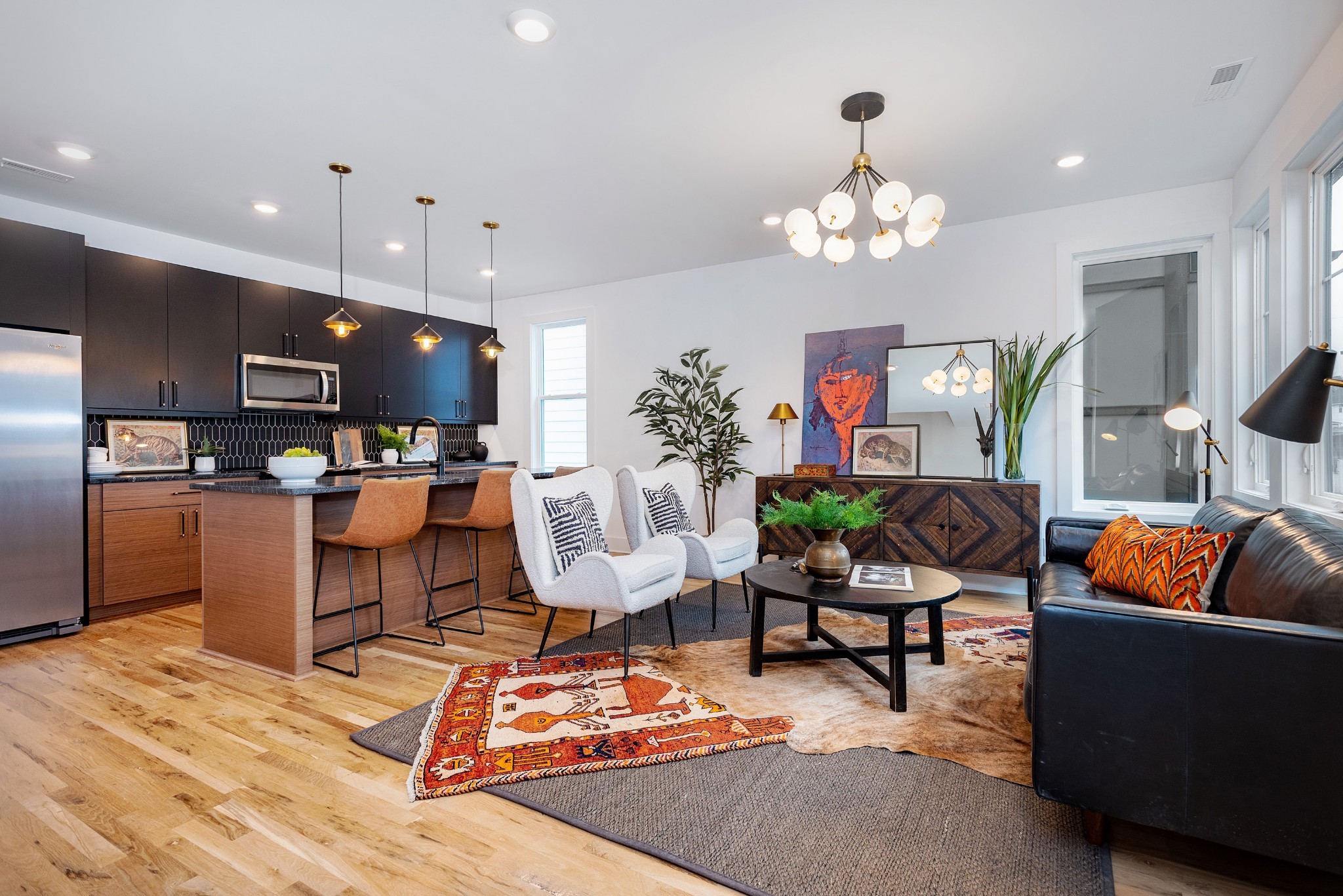 a living room with furniture kitchen view and a chandelier