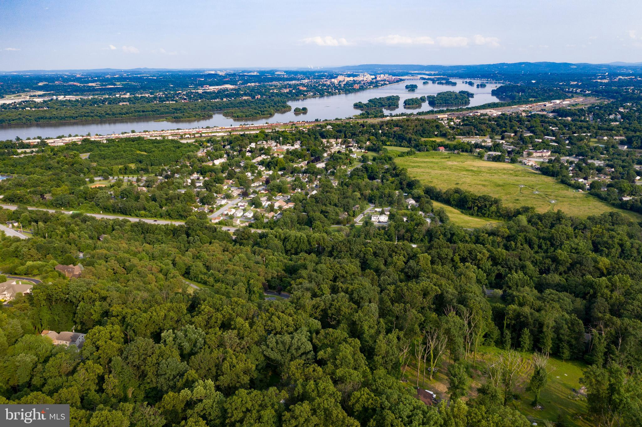 an aerial view of residential houses with outdoor space and trees