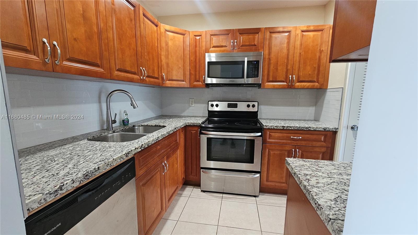 a kitchen with stainless steel appliances granite countertop a stove microwave and sink