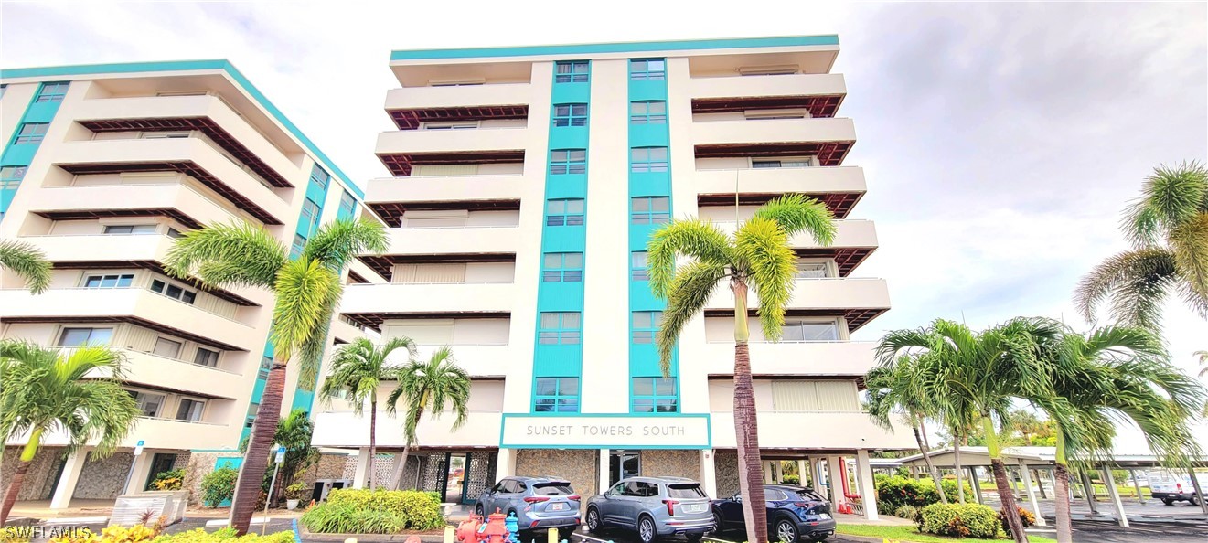 a view of a tall building with a lot of windows and plants