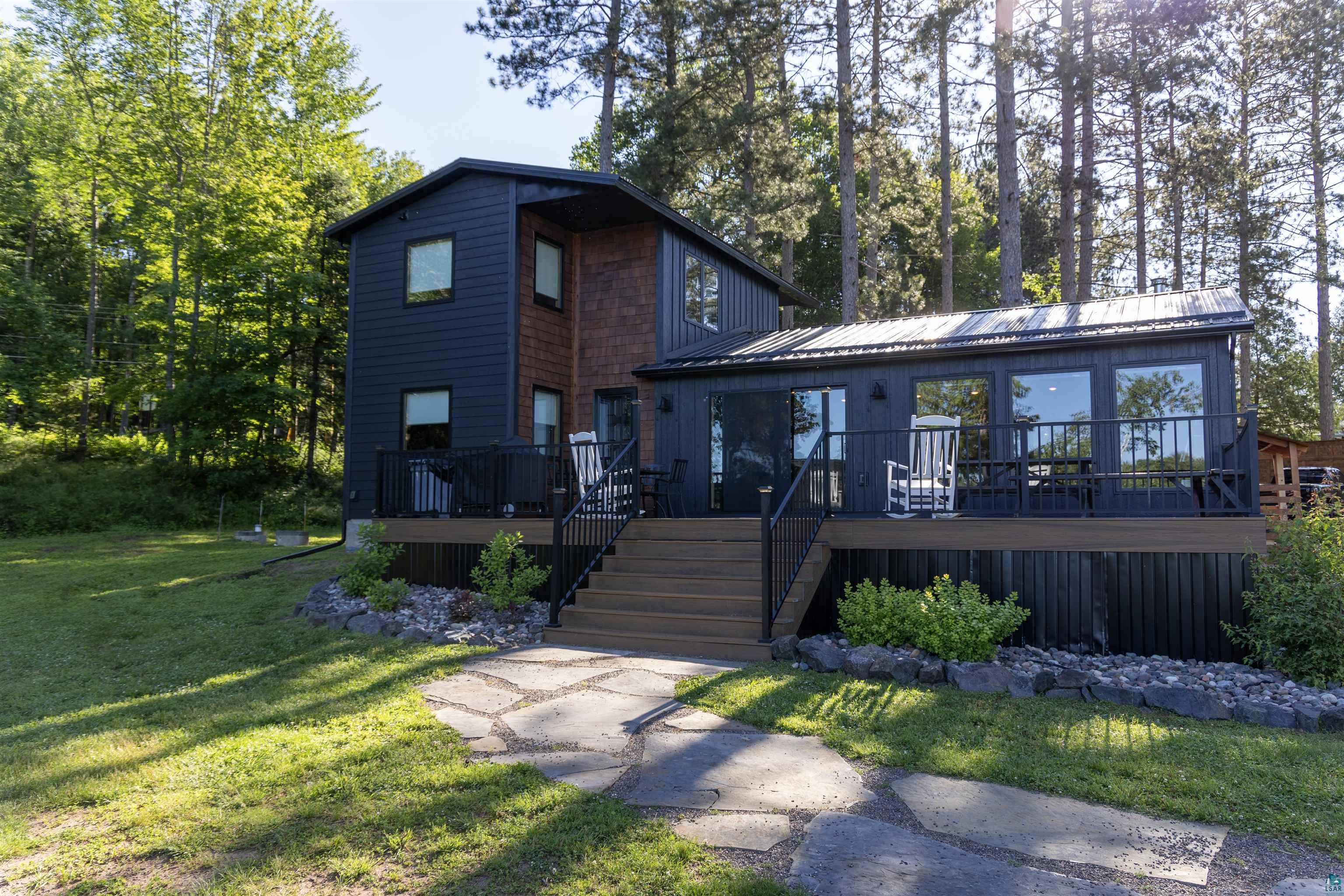 View of front facade with a front yard and a deck