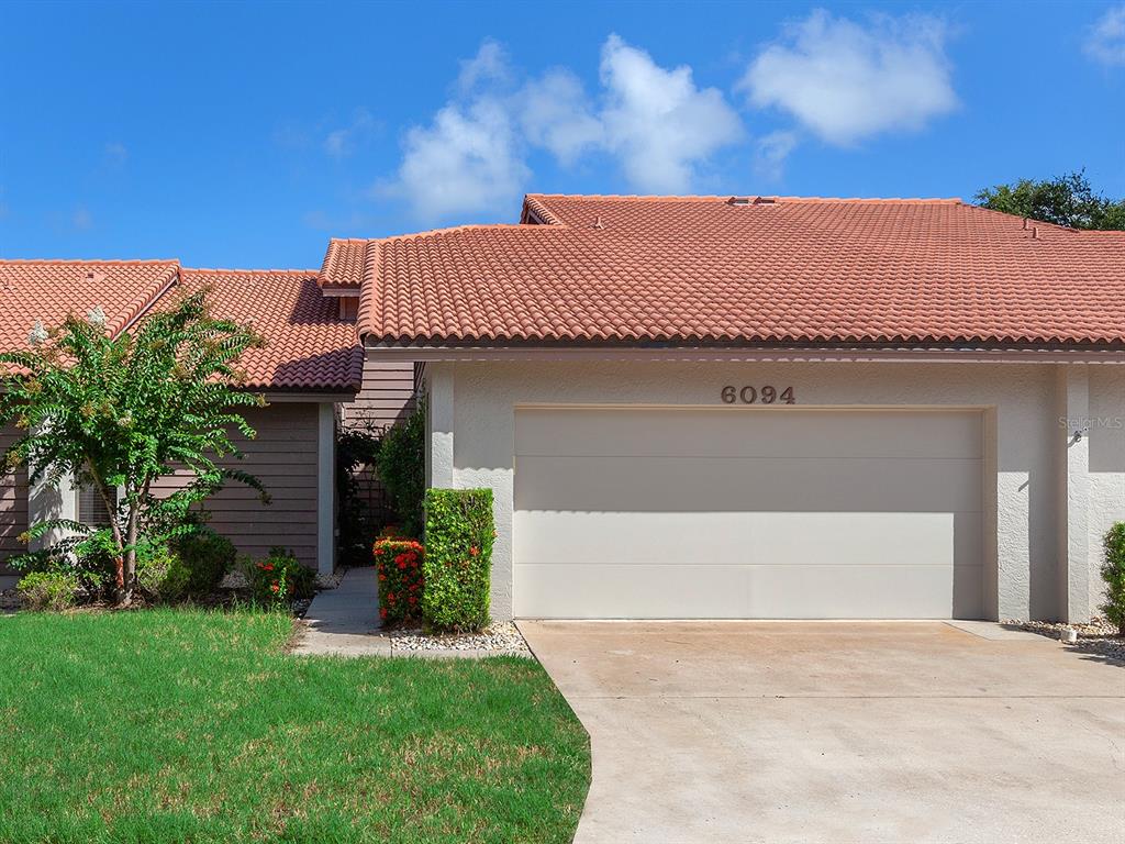 a front view of a house with a garden and yard