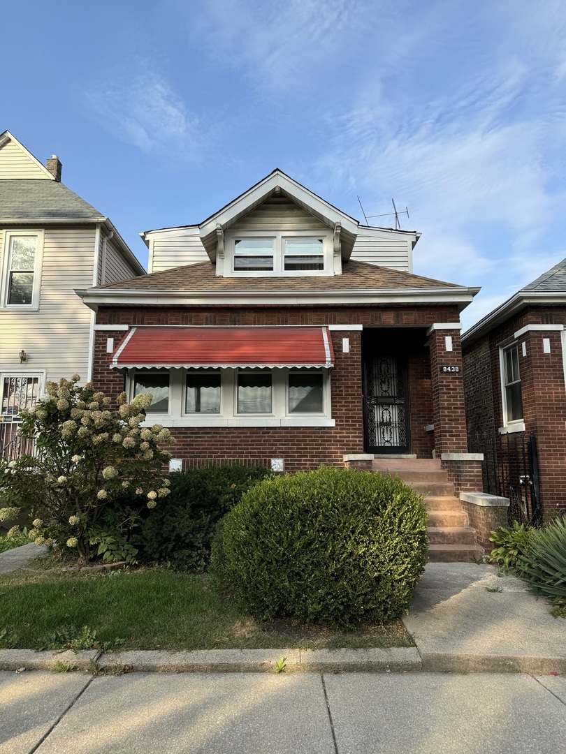 a front view of a house with a garden and plants