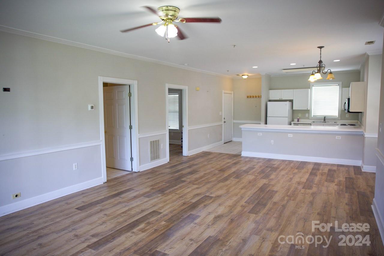 a view of an empty room and kitchen view