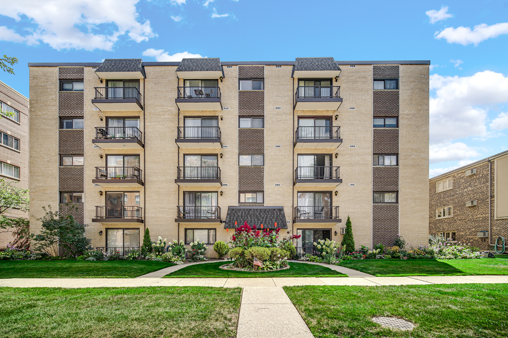 front view of a residential apartment building with a yard