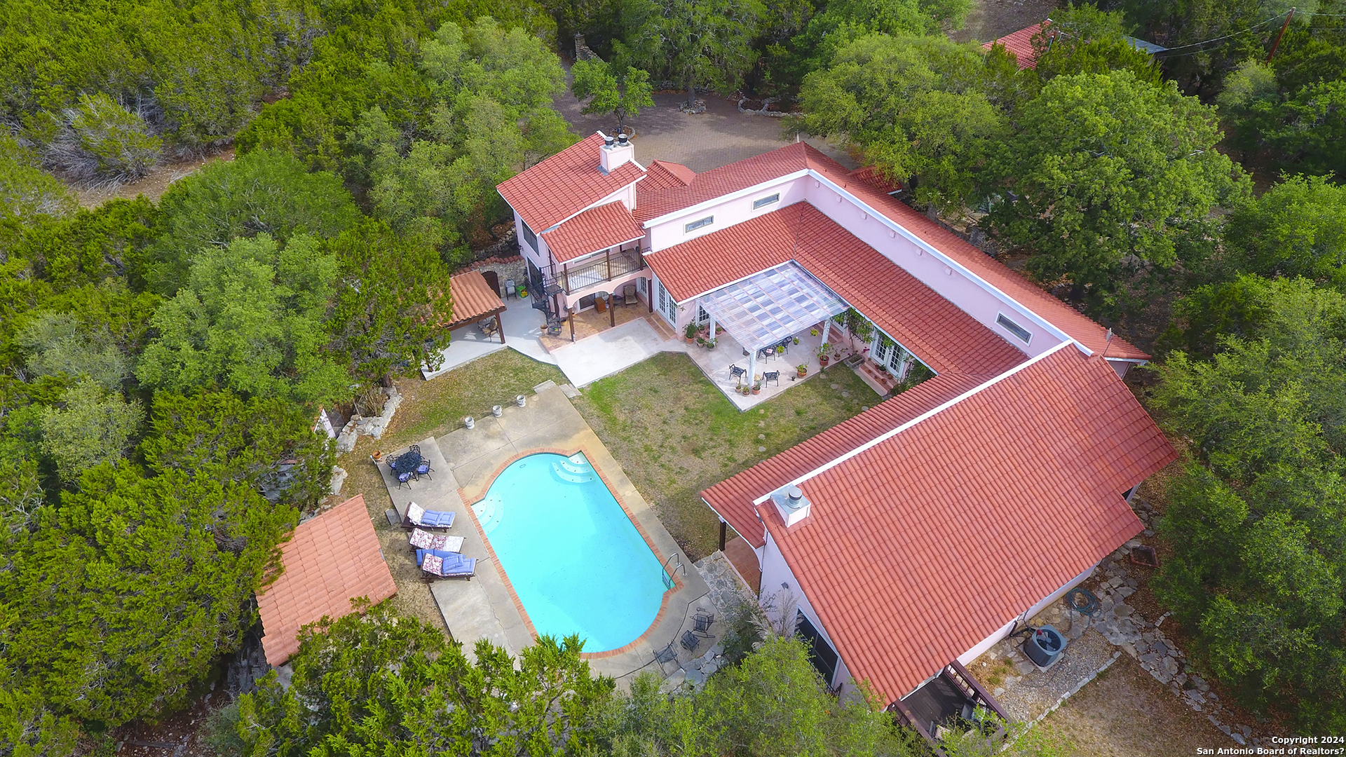 an aerial view of a house with a swimming pool and yard