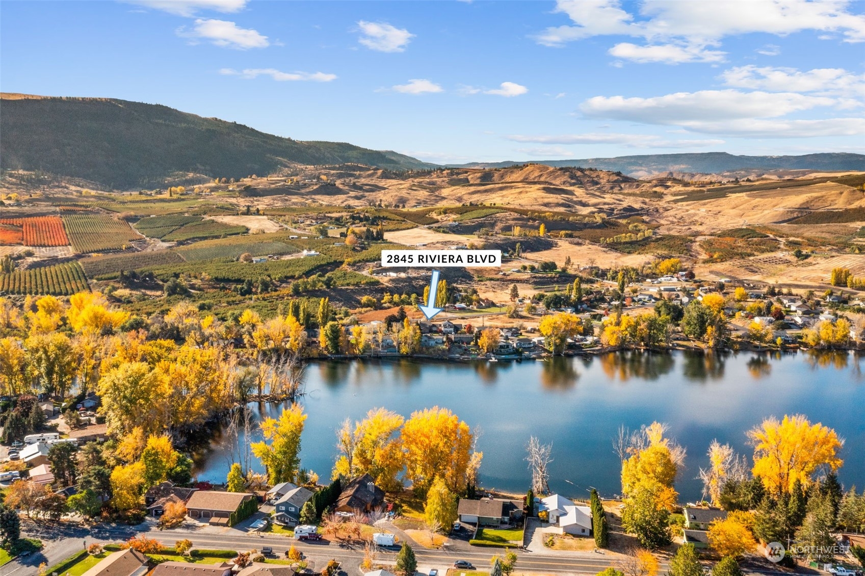 an aerial view of residential houses with outdoor space and lake view