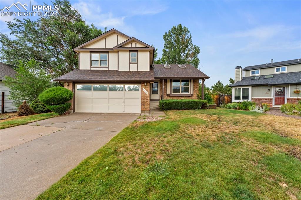 a front view of a house with a yard and garage