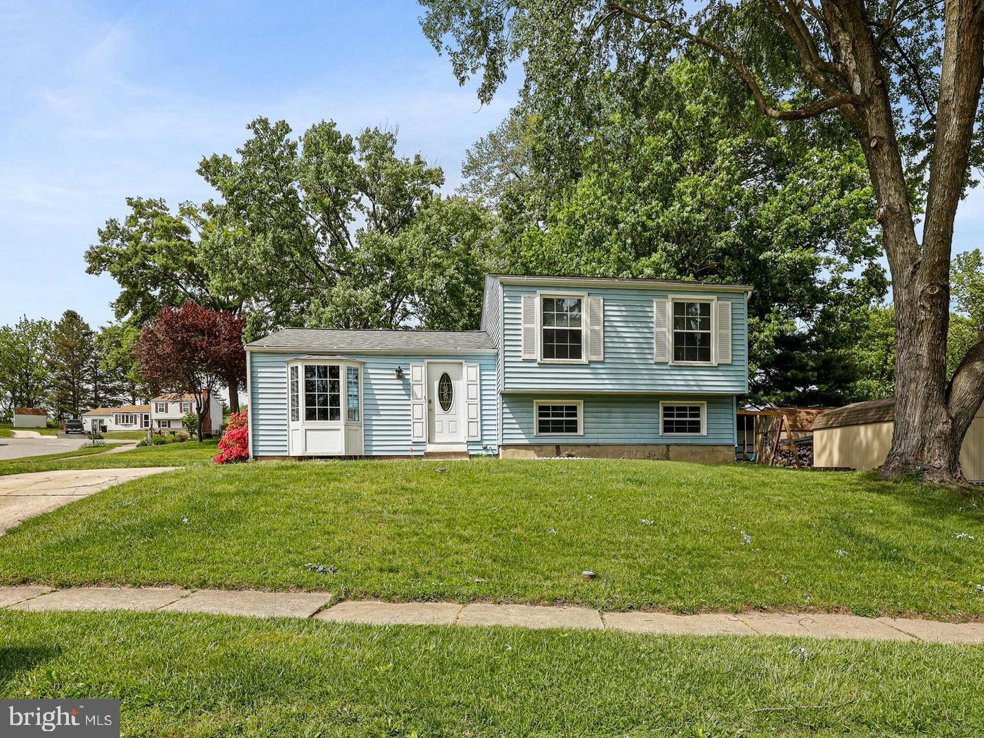 a house that has a big yard with plants and trees