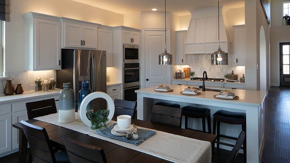 a kitchen with kitchen island granite countertop a sink cabinets and stainless steel appliances