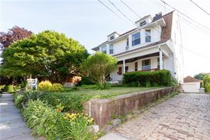 a front view of a house with a yard and a fence