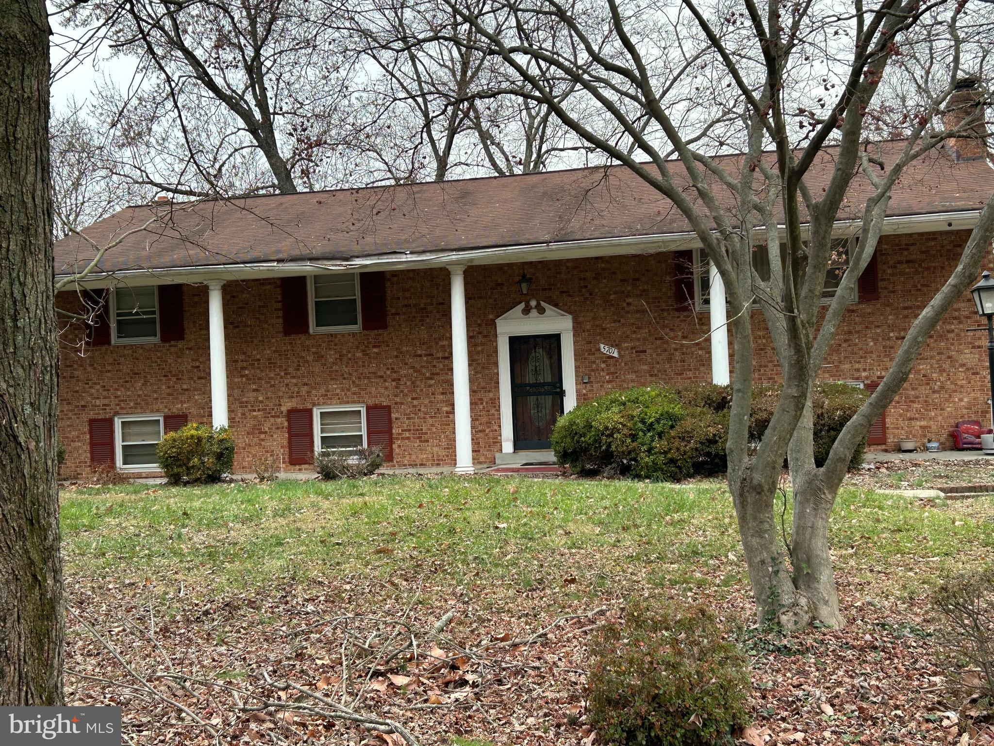 a view of a brick house with a large windows and a large tree