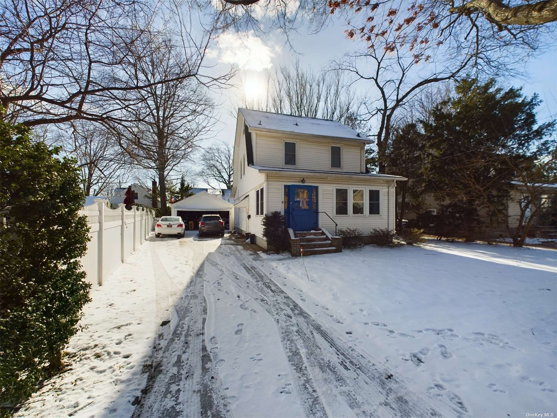 a front view of a house with a yard covered in snow