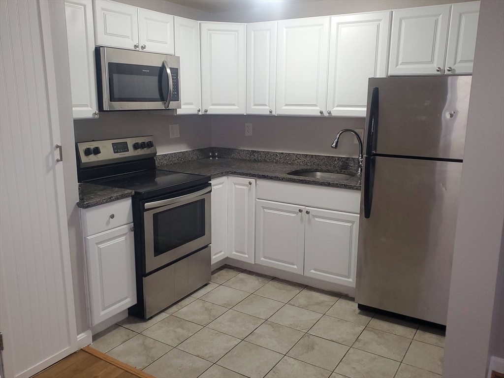 a kitchen with cabinets stainless steel appliances and counter space