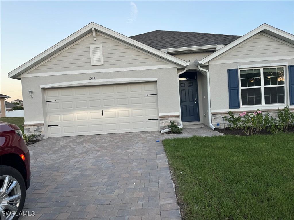 a front view of a house with a yard and garage