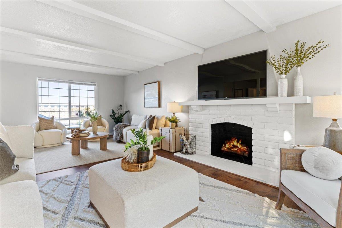 a living room with furniture a flat screen tv and a fireplace