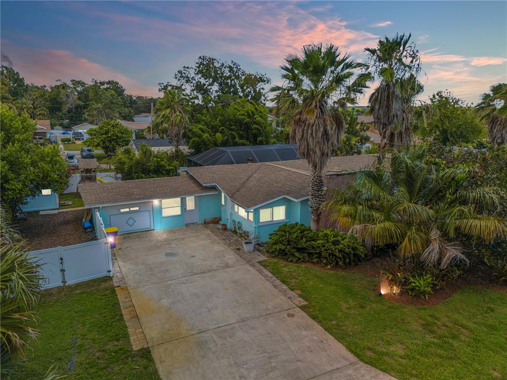 an aerial view of a house with garden space and trees