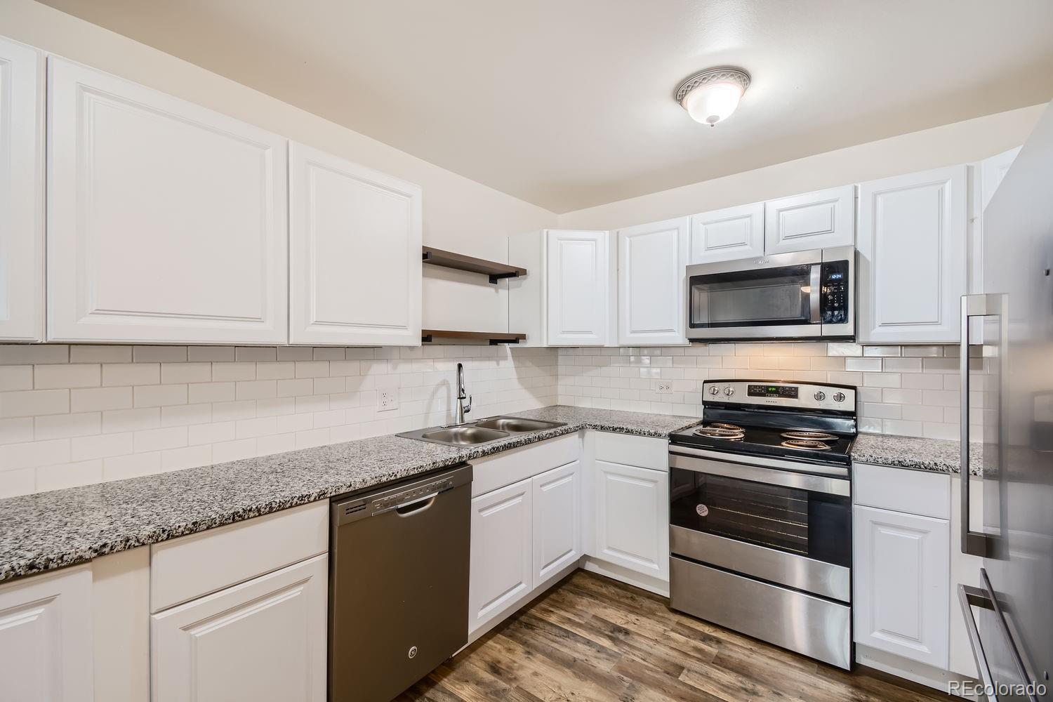 a kitchen with cabinets stainless steel appliances and sink