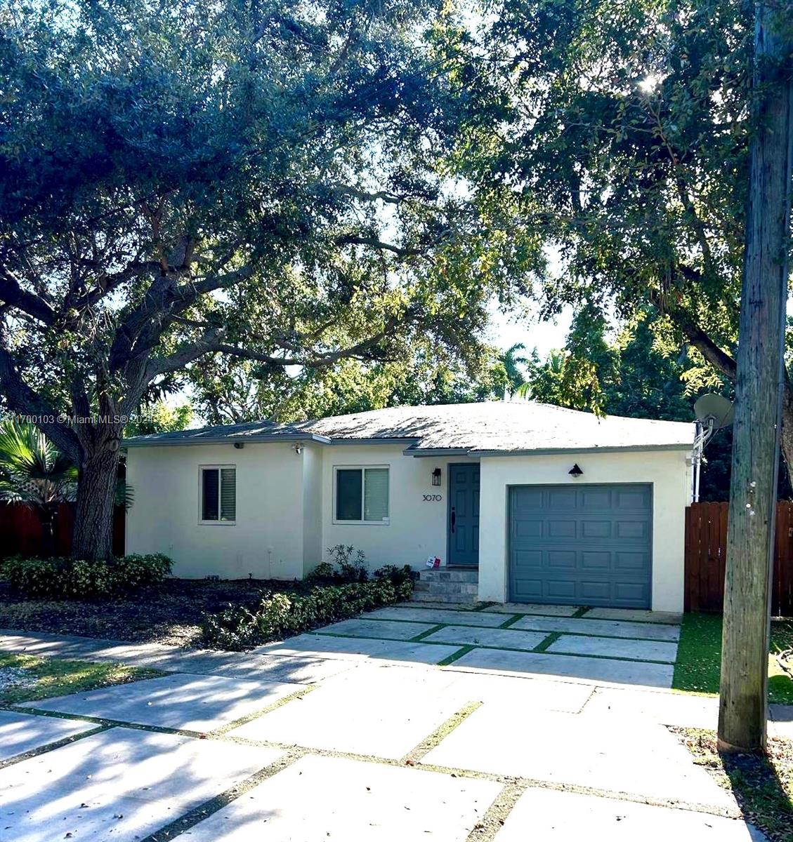 a view of house with yard and tree in front of it