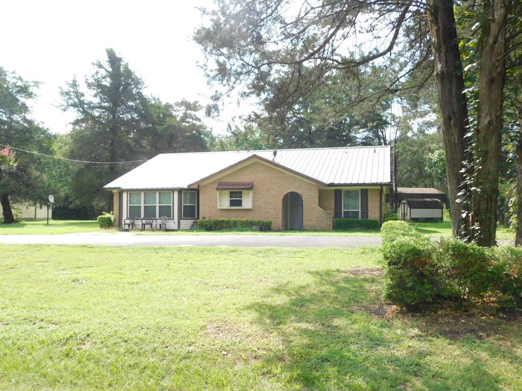 a front view of a house with yard patio and green space