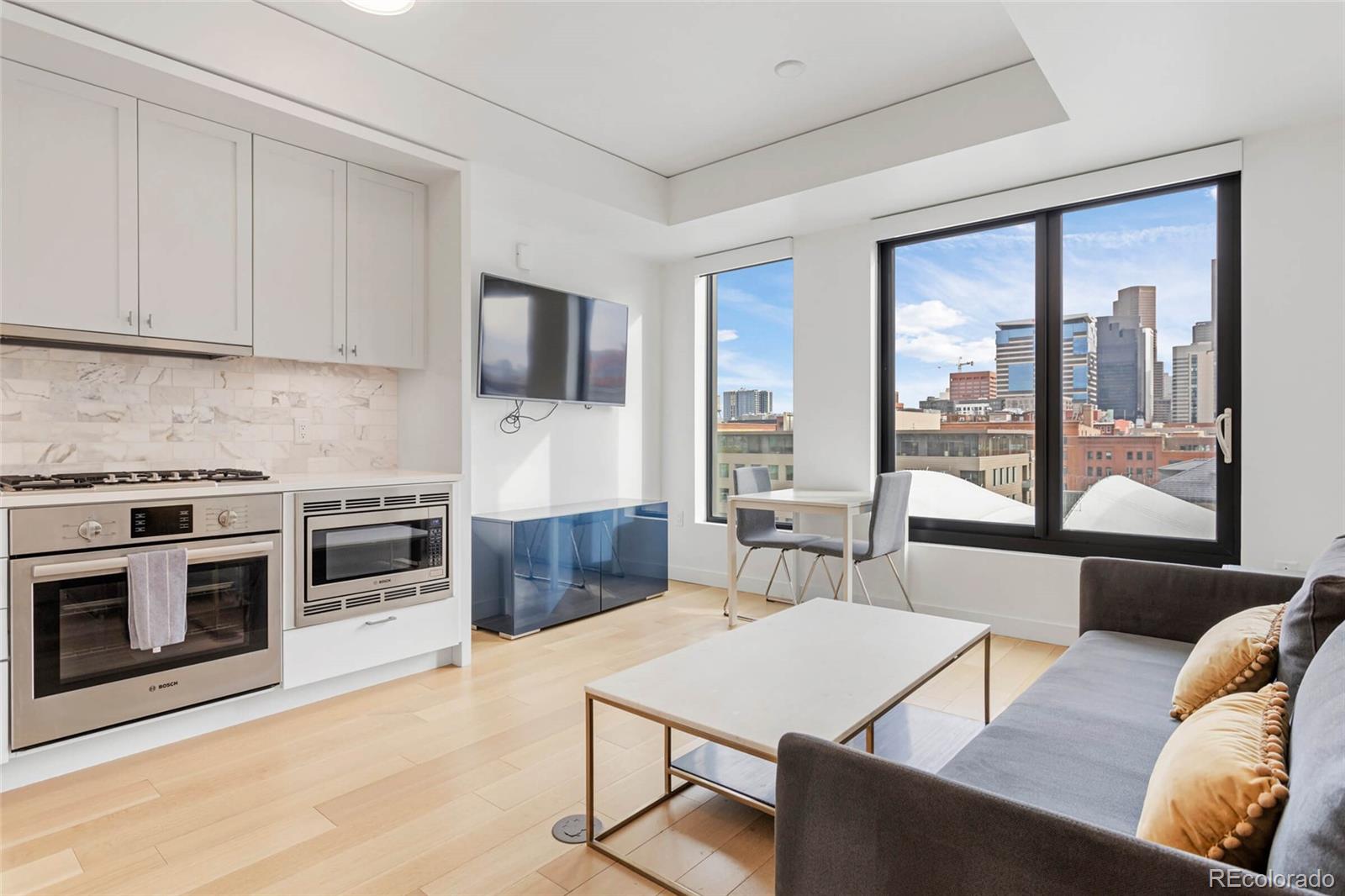 a living room with furniture a flat screen tv and a floor to ceiling window