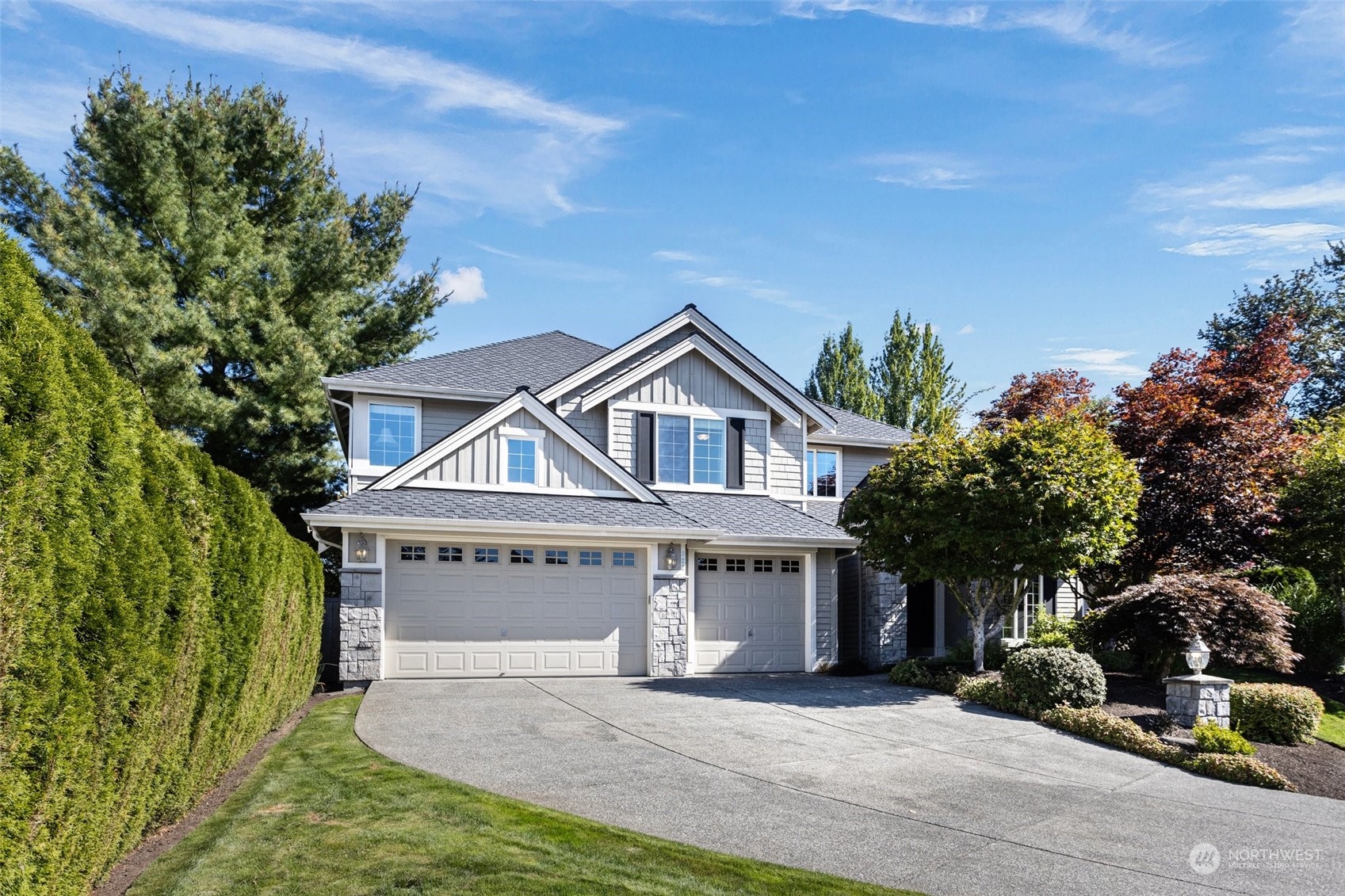 a front view of a house with a garden and trees